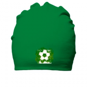 Бавовняна шапка з футбольним м'ячем на фоні зелені