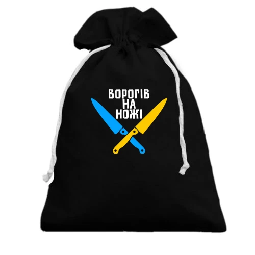 Подарунковий мішечок із двома схрещеними синьо-жовтими ножами та написом «ВОРОГІВ НА НОЖІ»